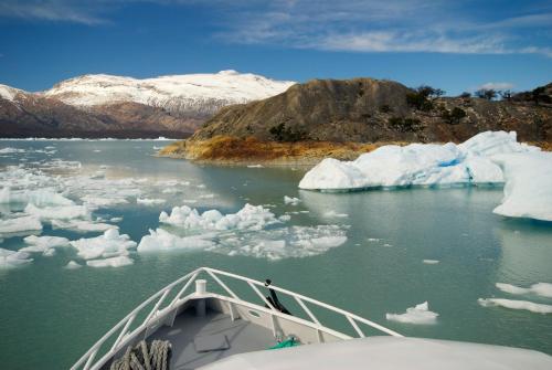 a boat in a body of water with icebergs at Kiritina´s House Homestay in El Calafate