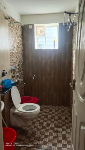 a bathroom with a toilet and a window at 305 Home Stay in Mangalore