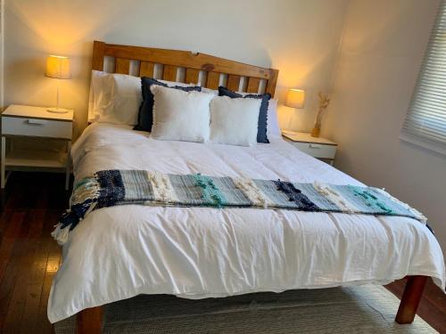 Un dormitorio con una cama grande con dos mesitas de noche. en Honey at KI, en Kingscote