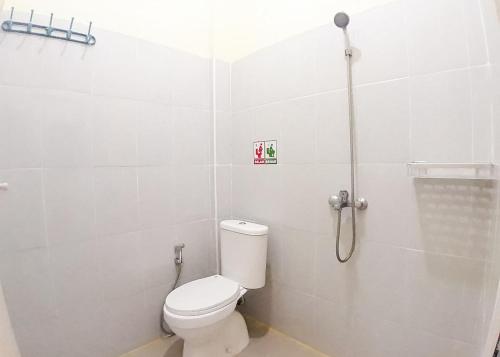 a bathroom with a toilet and a shower at RedDoorz Syariah near Transmart Jambi 2 in Paalmerah