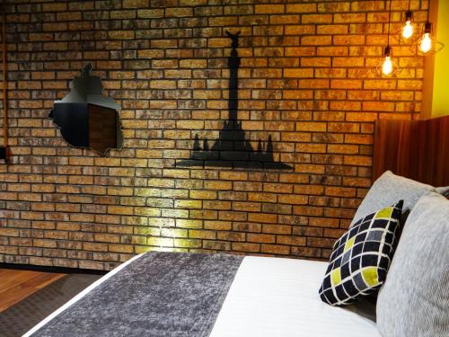 a bedroom with a brick wall with a bed and a lamp at Cadillac Hotel Boutique in Mexico City