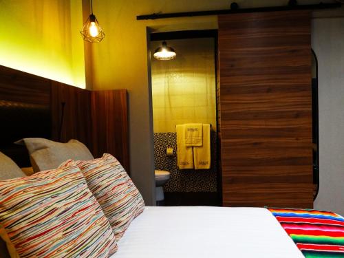 a hotel room with a bed and a bathroom at Cadillac Hotel Boutique in Mexico City