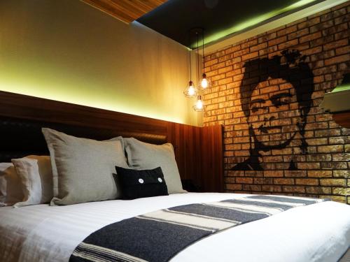a bedroom with a brick wall and a bed at Cadillac Hotel Boutique in Mexico City