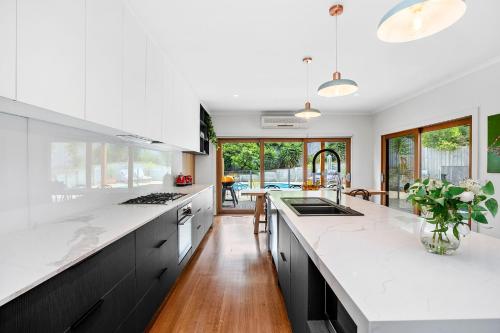 a kitchen with white countertops and a large island at Paws Up Poolside in Rye
