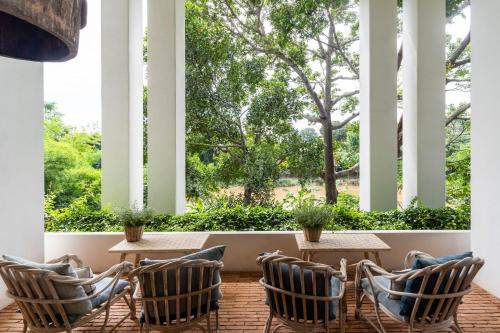 a porch with chairs and tables and a large window at Raya Heritage - SHA Plus in Chiang Mai