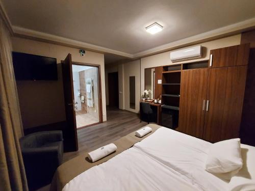 a hotel room with a large bed and a television at Vén Diófa De Lux Panzió in Szeged