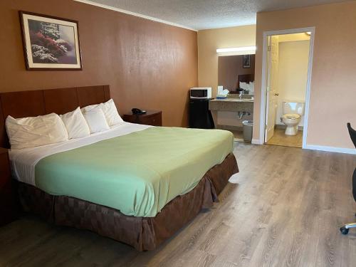 a hotel room with a bed and a bathroom at Travel Inn in Broadview