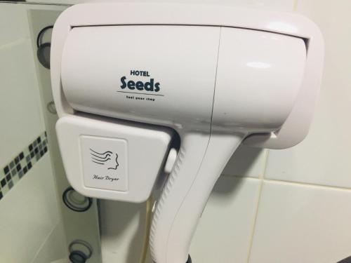 a white toilet in a bathroom with a sign on it at Seeds Hotel Wangsa Maju in Kuala Lumpur