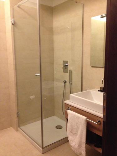 a glass shower in a bathroom with a sink at Eolian Milazzo Hotel in Milazzo