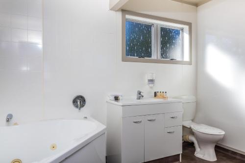 a white bathroom with a sink and a toilet at Twin Peaks Lakeside Inn in Taupo