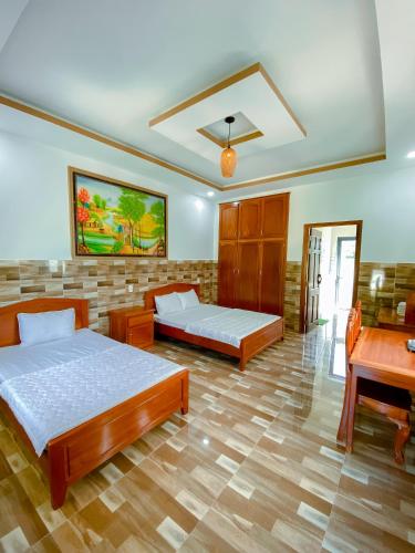 a bedroom with two beds and a desk at Phu My Hung Bungalow in Phu Quoc