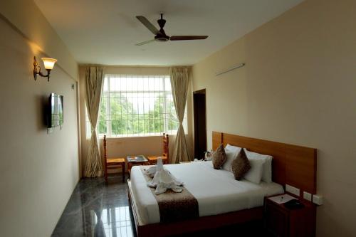 um quarto com uma cama e um ventilador de teto em ACK Palacce Inn em Yercaud