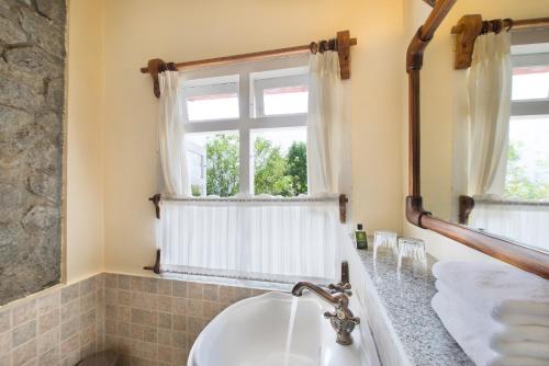 a bathroom with a sink and a window at Windermere Estate in Munnar