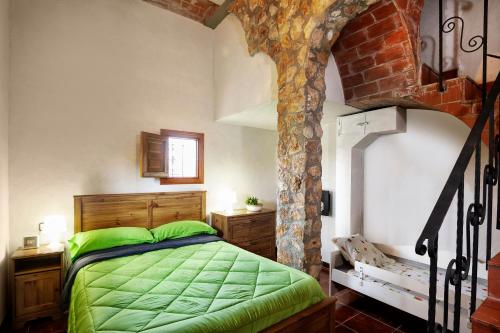 a bedroom with a bed with a green comforter at Finca Jabali in Tortosa