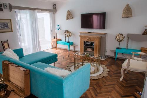 a living room with blue furniture and a tv at Au Temps D'antan- Ile Rodrigues in Rodrigues Island