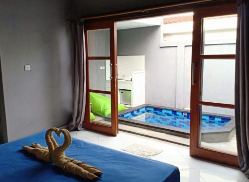 a room with a view of a swimming pool through a window at Kawans Inn in Nusa Lembongan