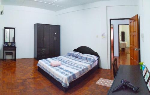 Un dormitorio con una cama y una mesa. en Victoria Homestay Sibu - Next to Shopping Complex, Party Event & Large Car Park Area with Autogate en Sibu