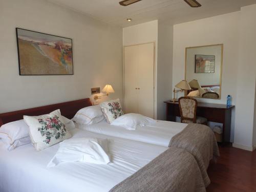 タレガにあるHotel Pintor Marsàのベッドルーム1室(白いシーツが備わるベッド2台付)