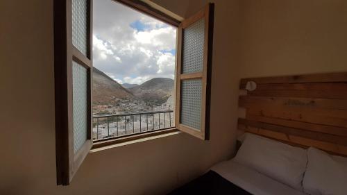 a bedroom with a window with a view of a city at Hotel Noche Azul in Real de Catorce