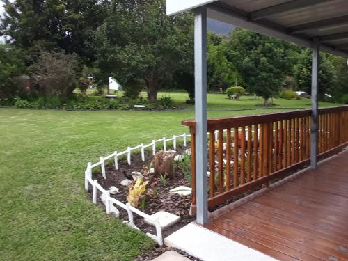 a garden on a porch with a fence at Nadine's Self - Catering Accommodation in Stormsrivier
