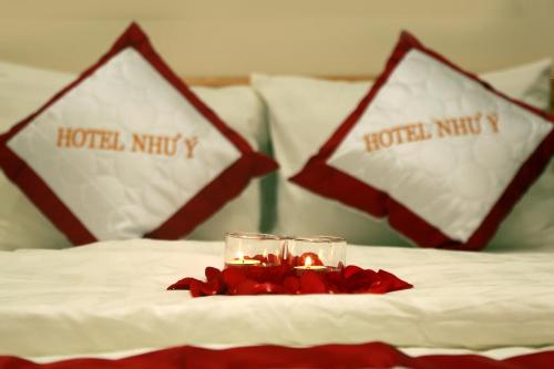 a table with two glasses and a candle on a bed at Hotel Như ý Biên Hòa in Bien Hoa