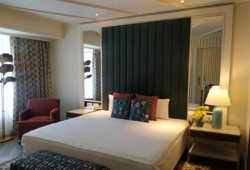 a bedroom with a large white bed and a chair at Blue Diamond Pune IHCL SeleQtions in Pune