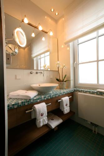 a bathroom with a sink and a large mirror at Strand-Hotel Seenelke in Wilhelmshaven
