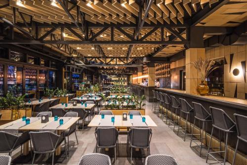 a restaurant with tables and chairs and a bar at GOOD ZONE Hotel in Peschanka
