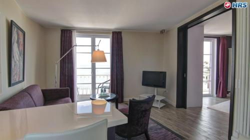 ein Wohnzimmer mit einem Sofa, einem Tisch und einem TV in der Unterkunft Apart Hotel Seenelke in Wilhelmshaven
