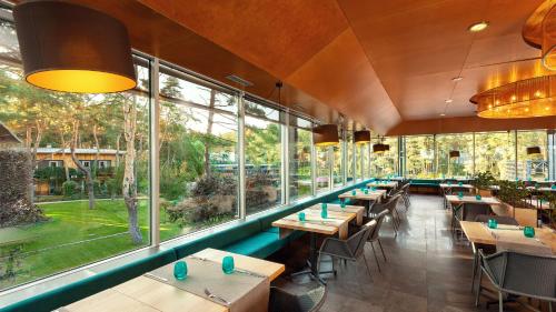 a restaurant with tables and chairs and large windows at GOOD ZONE Hotel in Peschanka