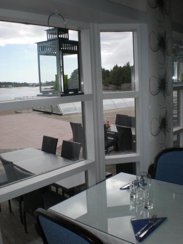 a dining room with tables and chairs and windows at Käringsund Resort in Eckerö