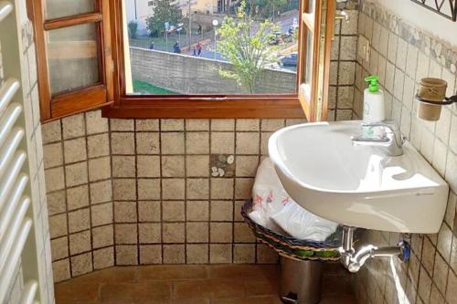 a bathroom with a sink and a window at Appartamento rustico con vista in Montelupo Fiorentino