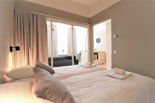 1 Schlafzimmer mit 2 Betten und einem großen Fenster in der Unterkunft Forenom Aparthotel Vaasa in Vaasa