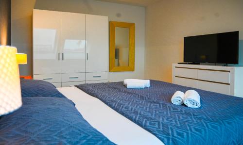 een slaapkamer met een bed met handdoeken en een flatscreen-tv bij Delightful Duplex Danube Canal in Wenen