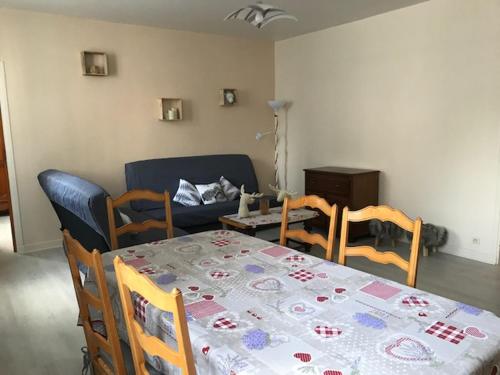 un salon avec une table, des chaises et un canapé dans l'établissement Appartement 4 - 6 personnes avec Wifi Centre La Bourboule, à La Bourboule