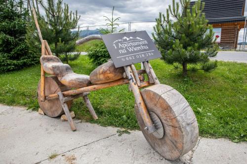a wooden bike with a sign on the back at Apartament Na Wierchu in Murzasichle