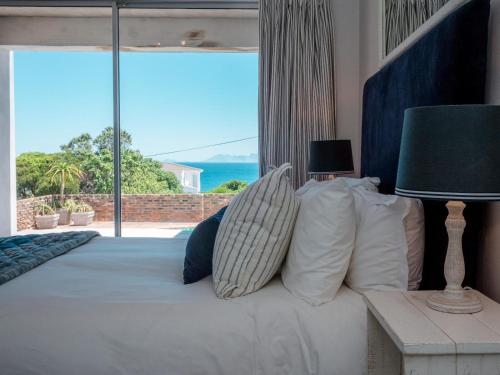 Un dormitorio con una cama con vista al mar. en Casey's Landing, en De Kelders