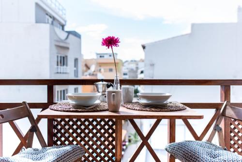 a table with two bowls and a flower on a balcony at Don Antonio Cristianos Beach Vivienda vacacional in Los Cristianos