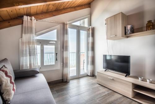 a living room with a couch and a television at Amore Del Mare in Amoudi