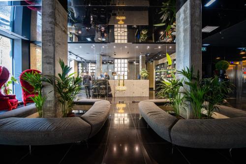 a lobby with couches and potted plants at 138 Liberdade Hotel in Lisbon