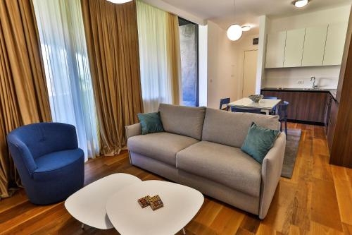 a living room with a couch and a blue chair at Royal Montesun Apartments in Budva