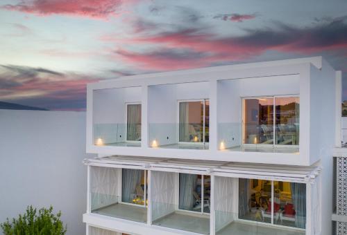 a white building with a sunset in the background at Kouros Exclusive Hotel & Suites - Adults Only in Faliraki