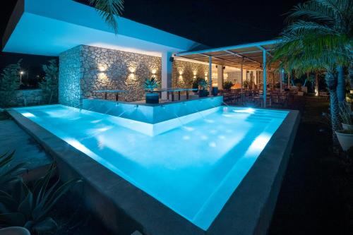 a swimming pool in a house at night at Kouros Exclusive Hotel & Suites - Adults Only in Faliraki