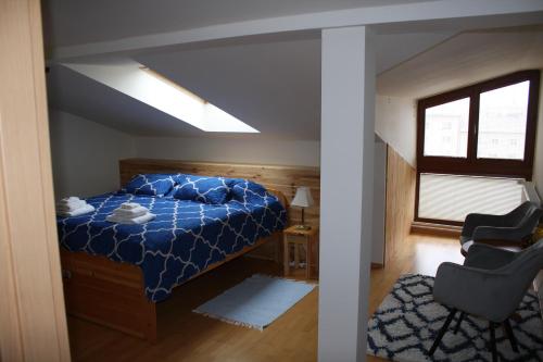 a bedroom with a blue bed and a chair at RENMIR in Poprad