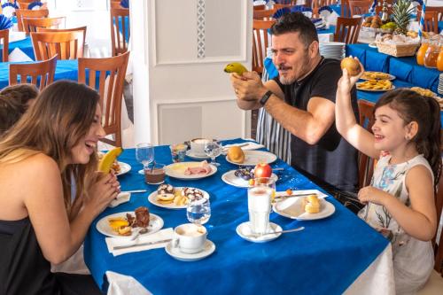 a man feeding a group of people at a table with food at Hotel Holland in Rimini