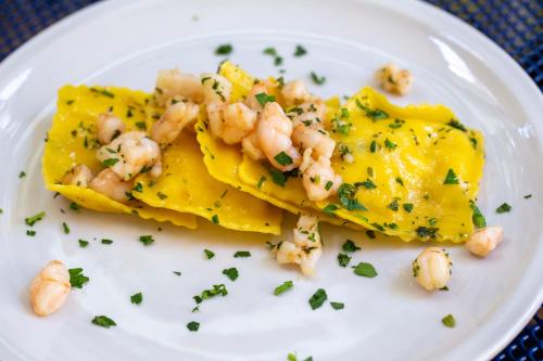a plate of food with shrimp on top at Hotel Holland in Rimini