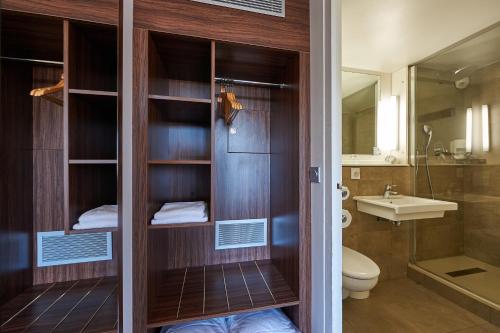 La salle de bains est pourvue de toilettes et d'un lavabo. dans l'établissement Kyriad Bordeaux - Merignac Aéroport, à Mérignac