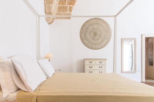 una camera da letto bianca con un letto grande e una finestra di Di Lorenzi Albergo Diffuso a Felline