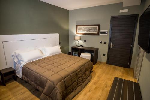 a bedroom with a bed and a table and a door at Hotel Europa Art Caserta in Caserta