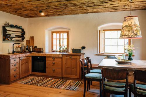 eine Küche mit einem Tisch und einem Esszimmer in der Unterkunft BAUERNHAUS DÖRFL IN DER STRASS in Reindlmühl